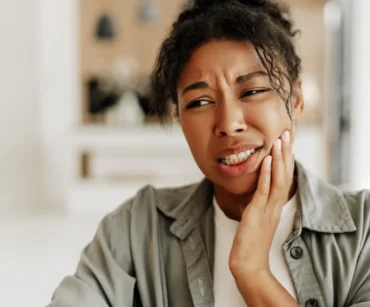 young woman suffering from strong toothache